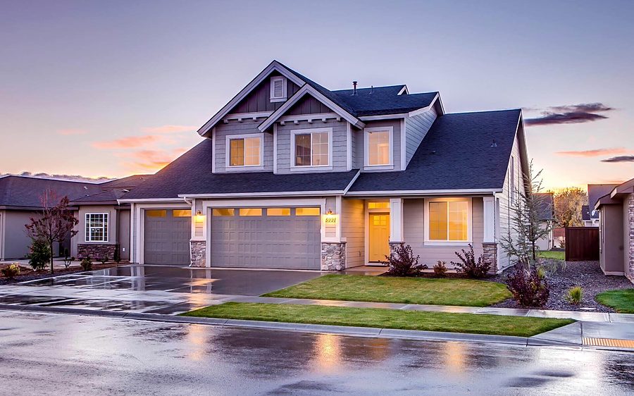 Newly built two-story home with its lights on at dusk